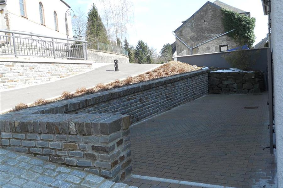 Stützmauer in hammerechten Mauersteinen mit Rollschichtabdeckung